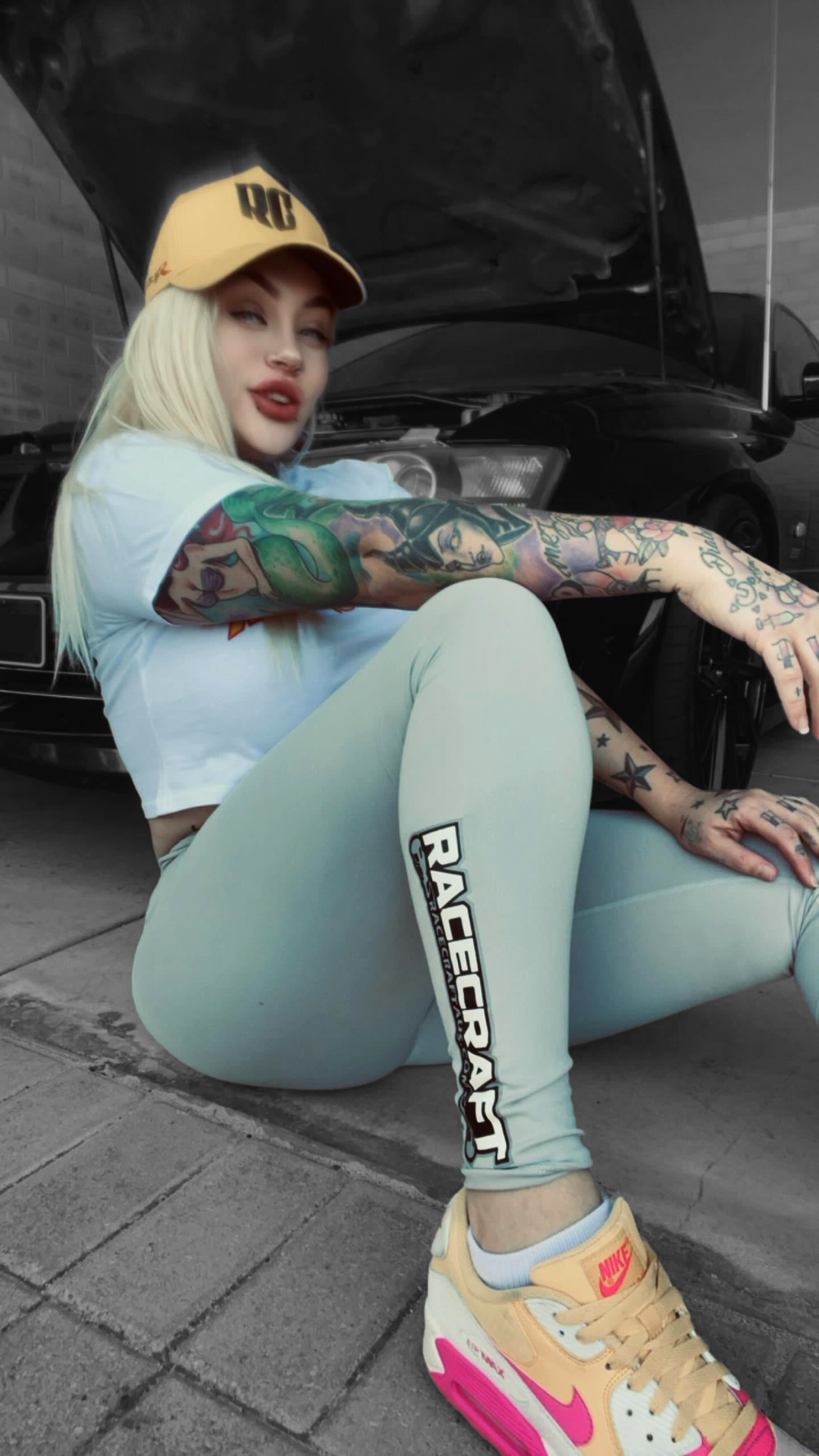 Girl wearing gray grey racecraft leggings with 'Racecraft' branding, sitting next to a car.