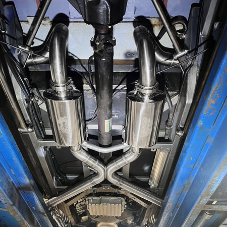 Close-up of a vehicle's custom exhaust system with stainless racecraft exhaust components 
