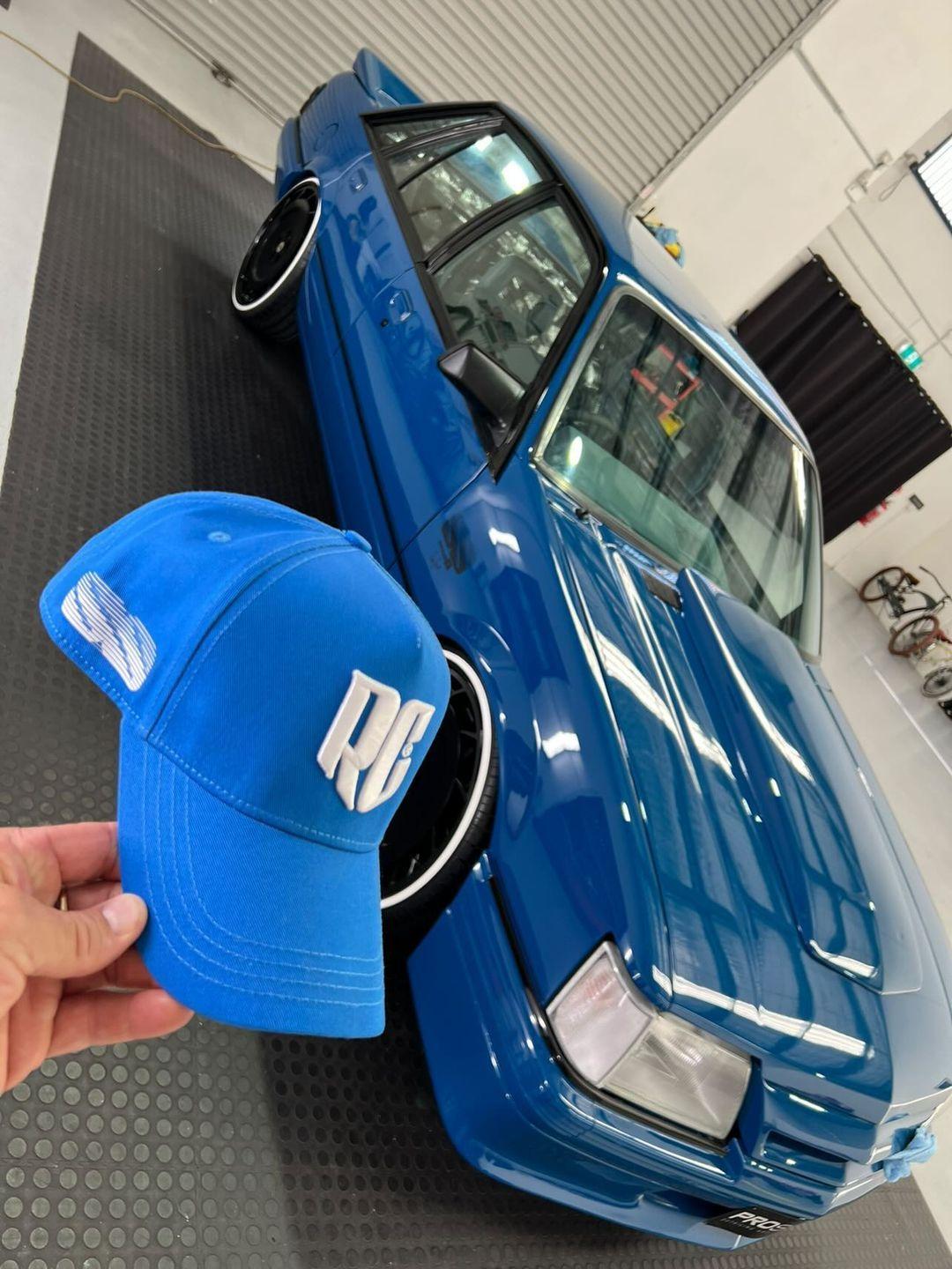 blue meanie vk ss group-a cap held in front of vk ss group a car