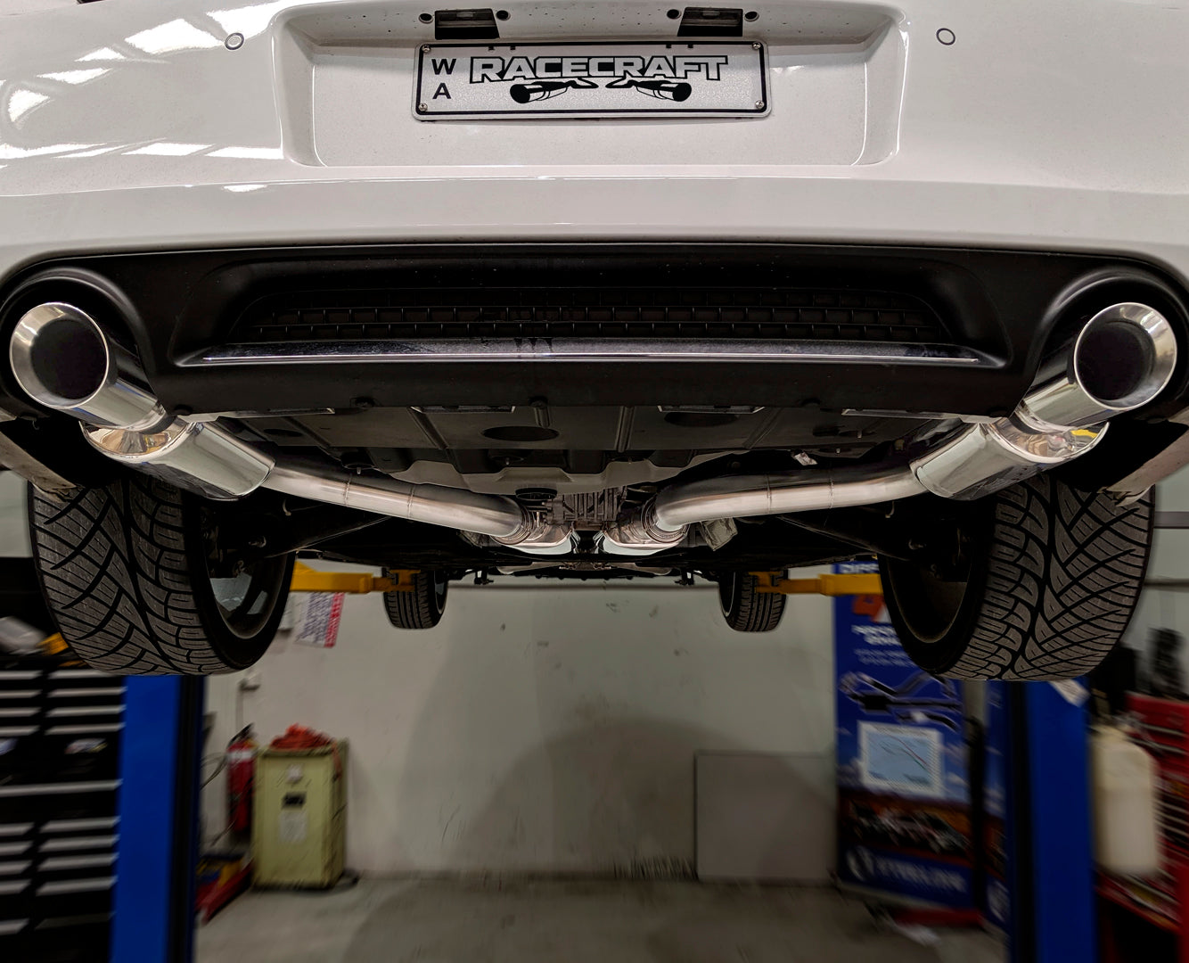 racecraft round stainless mufflers on chrysler 300c with custom exhaust at the rear view closeup